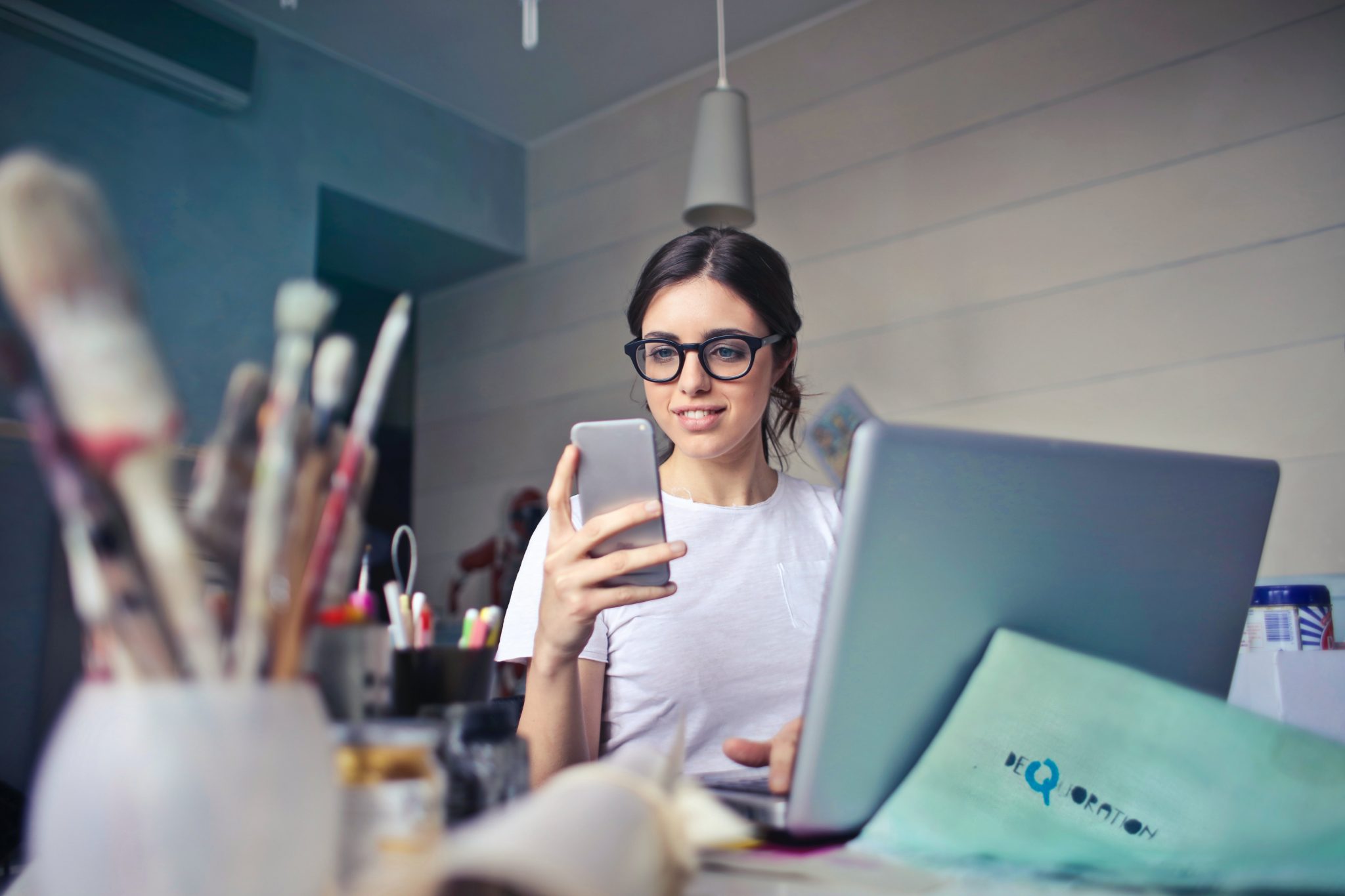 woman with thick rimmed glasses posting on social media